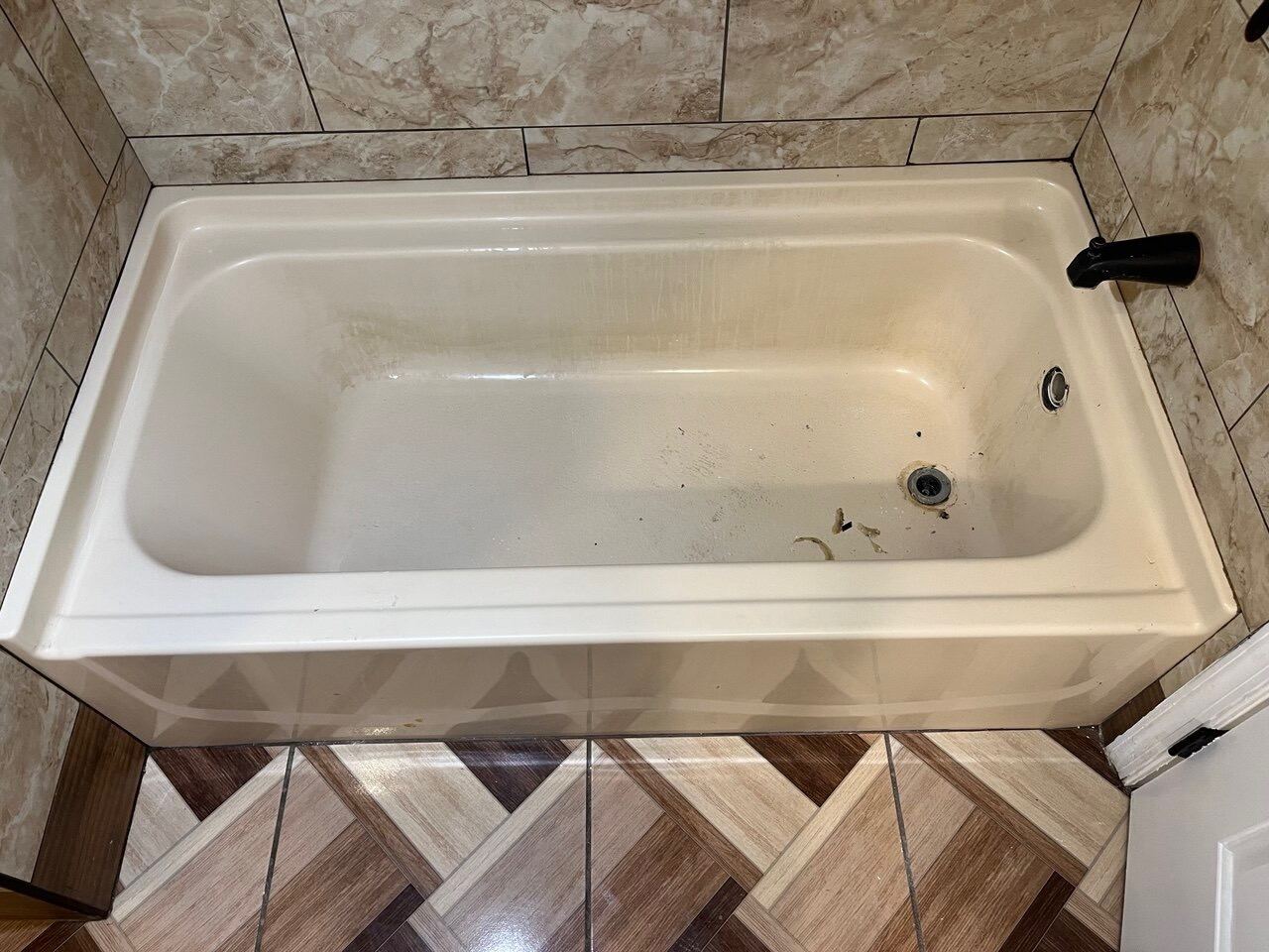 White bathtub with visible surface wear before refinishing