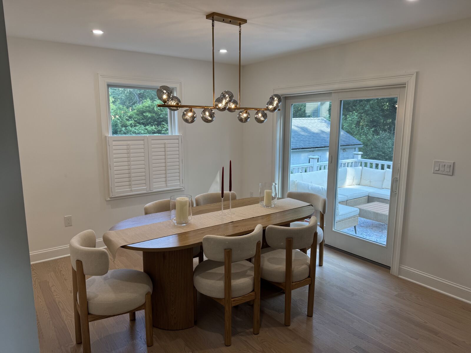 Finished dining-room interior with a chandelier, table, and sliding glass door