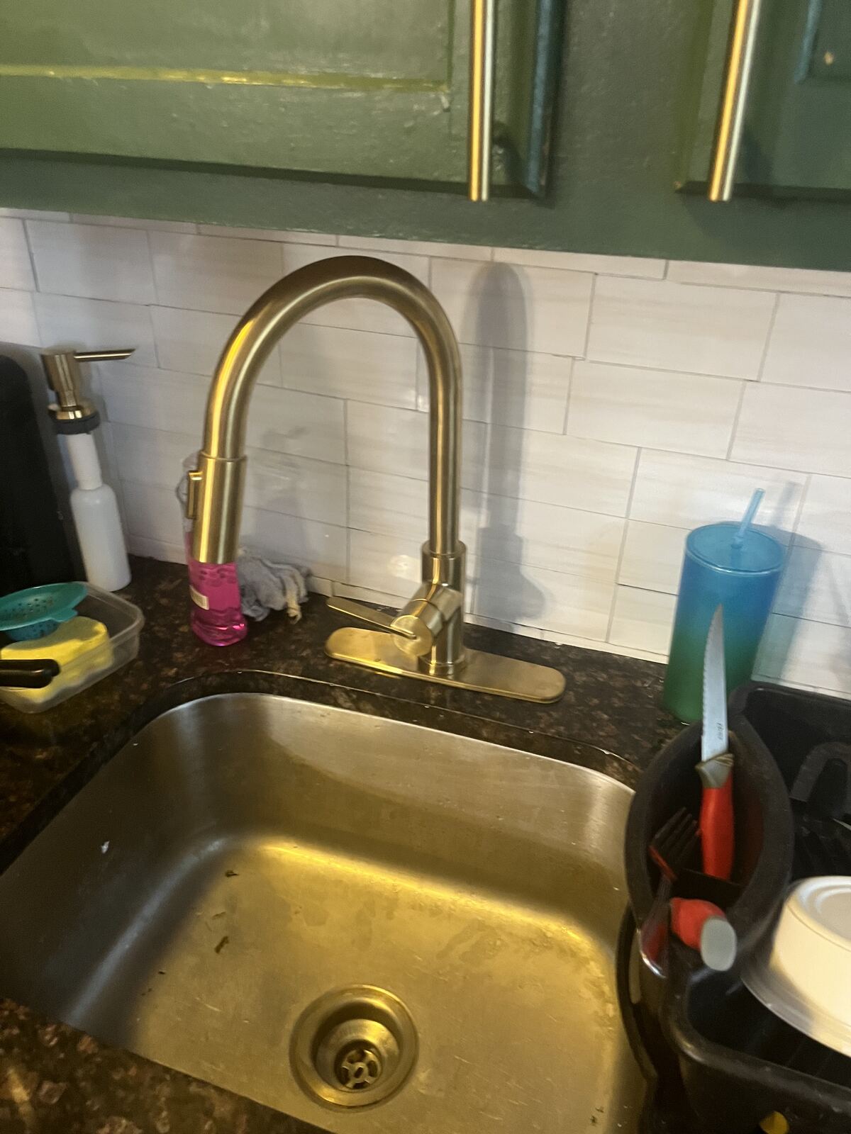 Gold-toned pull-down faucet mounted over a sink