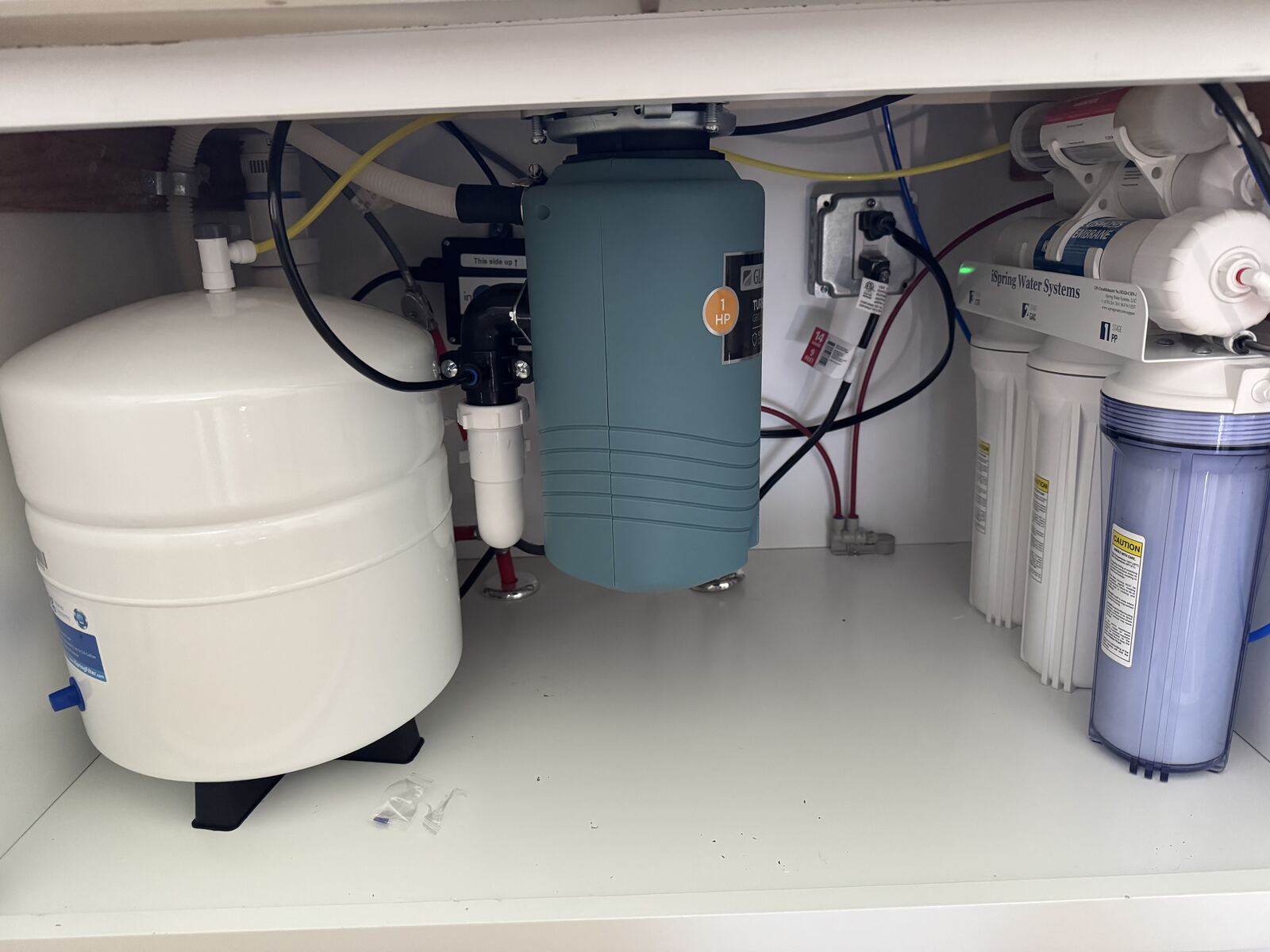 Under-sink cabinet with water filtration equipment and connected plumbing