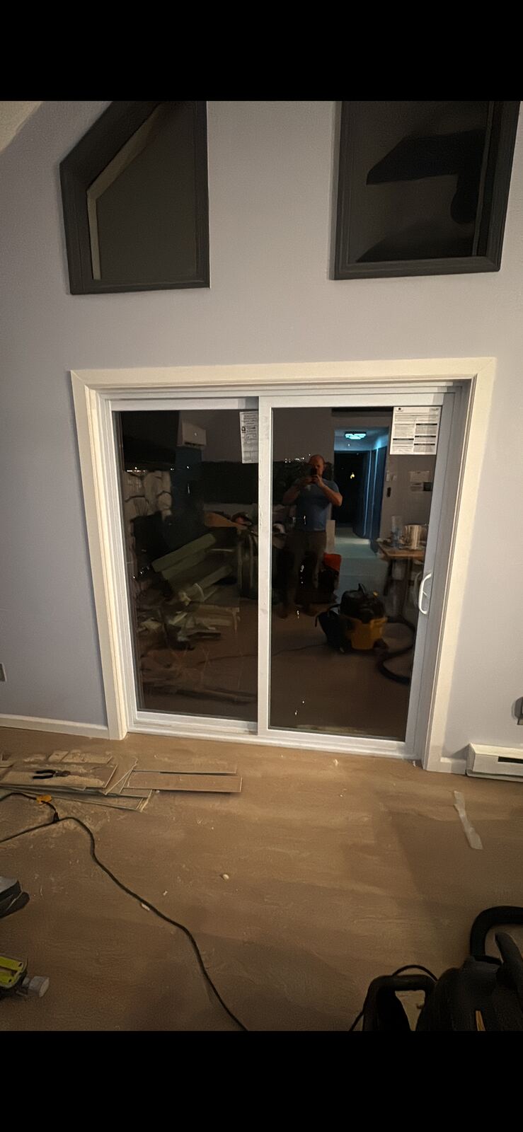 Sliding glass door in an interior room with tools and unfinished flooring nearby