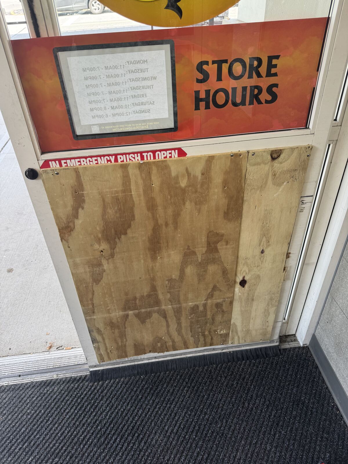 Commercial storefront door covered with a temporary plywood panel