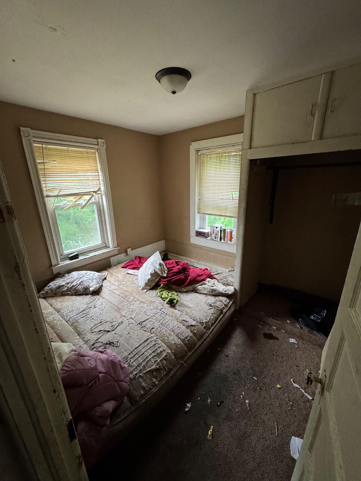 Bedroom with a bed and items on the floor before a turnover